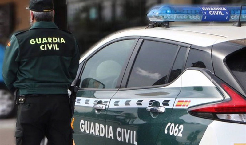 Un agente de la Guardia Civil, de espaldas, de pie junto a un vehículo oficial (GUARDIA CIVIL) Un agente de la Guardia Civil, de espaldas, de pie junto a un vehículo oficial (GUARDIA CIVIL)