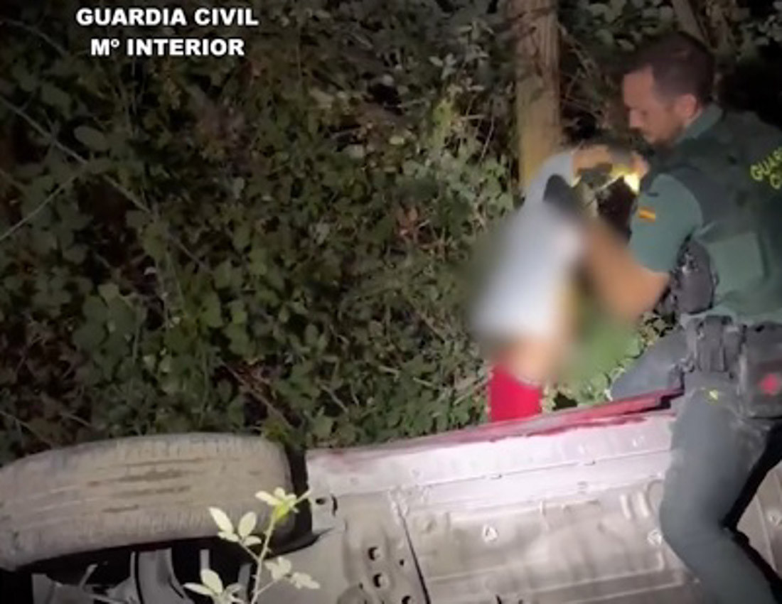 Momento en el que un guardia civil rescata a un niño de cuatro años que estaba en el interior de un coche suspendido entre la vegetación tras caer por un terraplén de 20 metros en Soportújar (GUARDIA CIVIL)