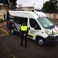 Agente de la Policía Local de Granada junto a un furgón en una foto de archivo
